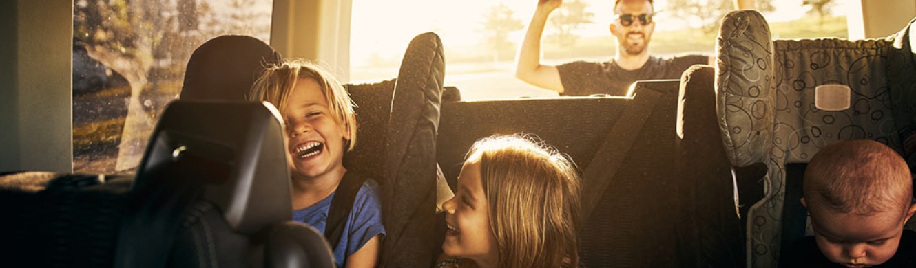 Kids and dad in car ready for a road trip 